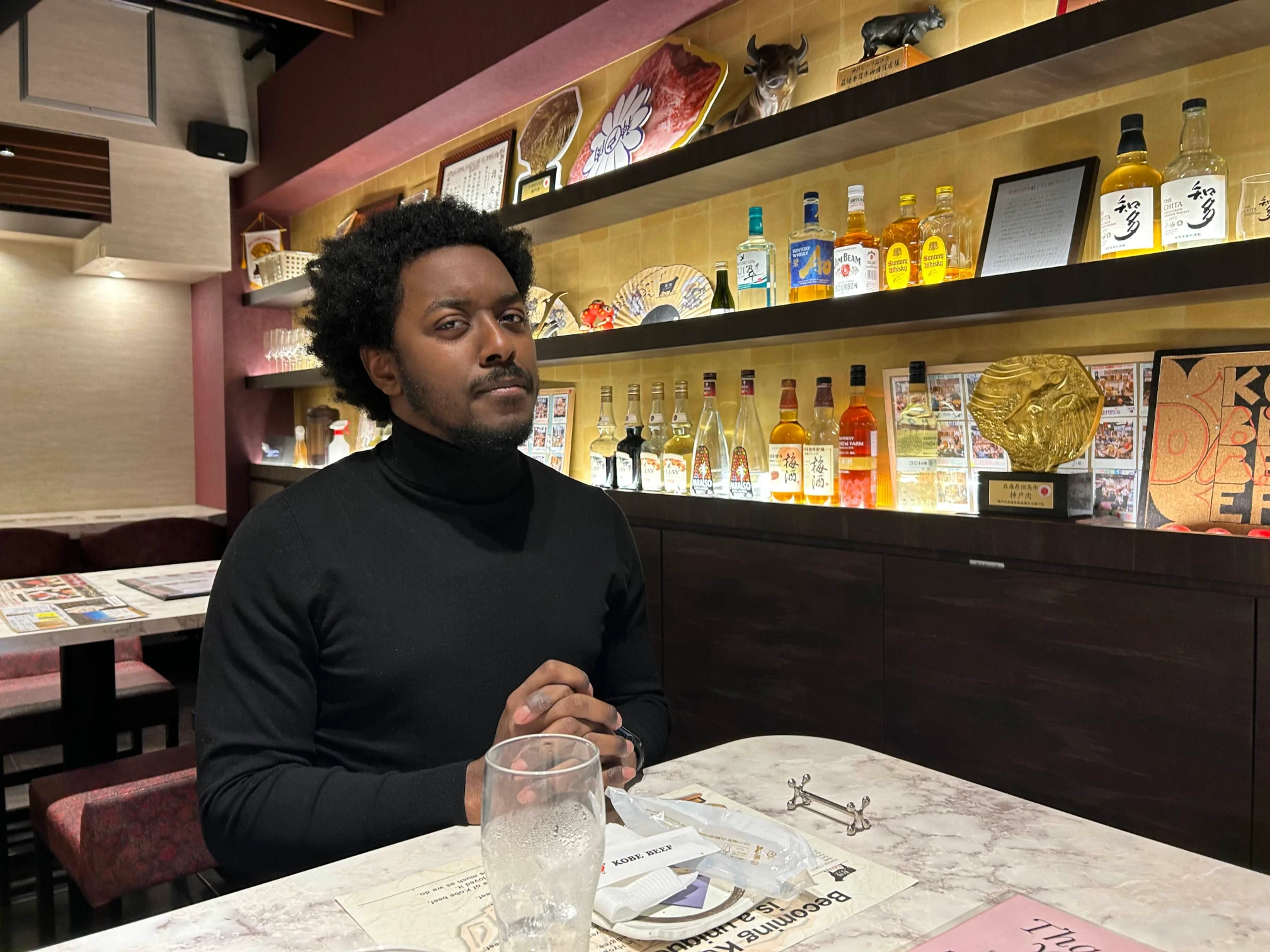 An immaculate photograph of the site author, Andre B. Dixon, aura-maxxing in a black turtleneck at a Wagyu joint in Tokyo.